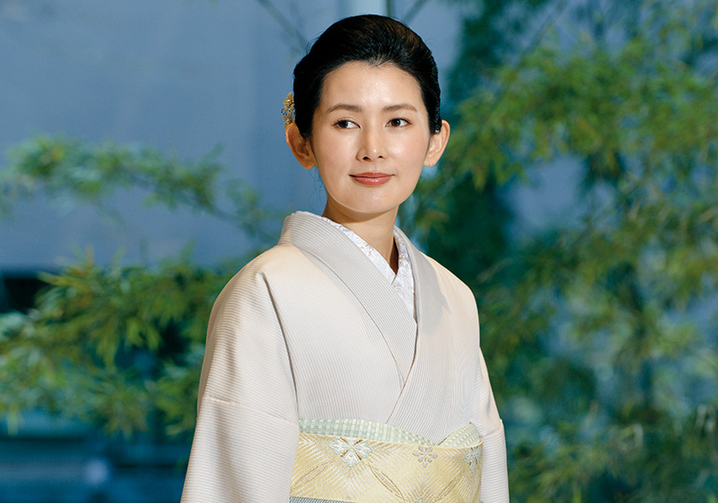 ベージュの色無地を着た女性